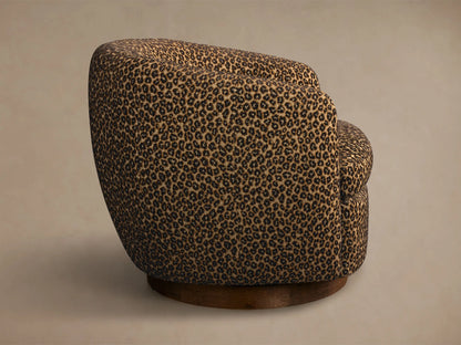 Side view of the Cerrito Swivel Chair, upholstered in brown and black leopard print fabric with a round dark wooden base.