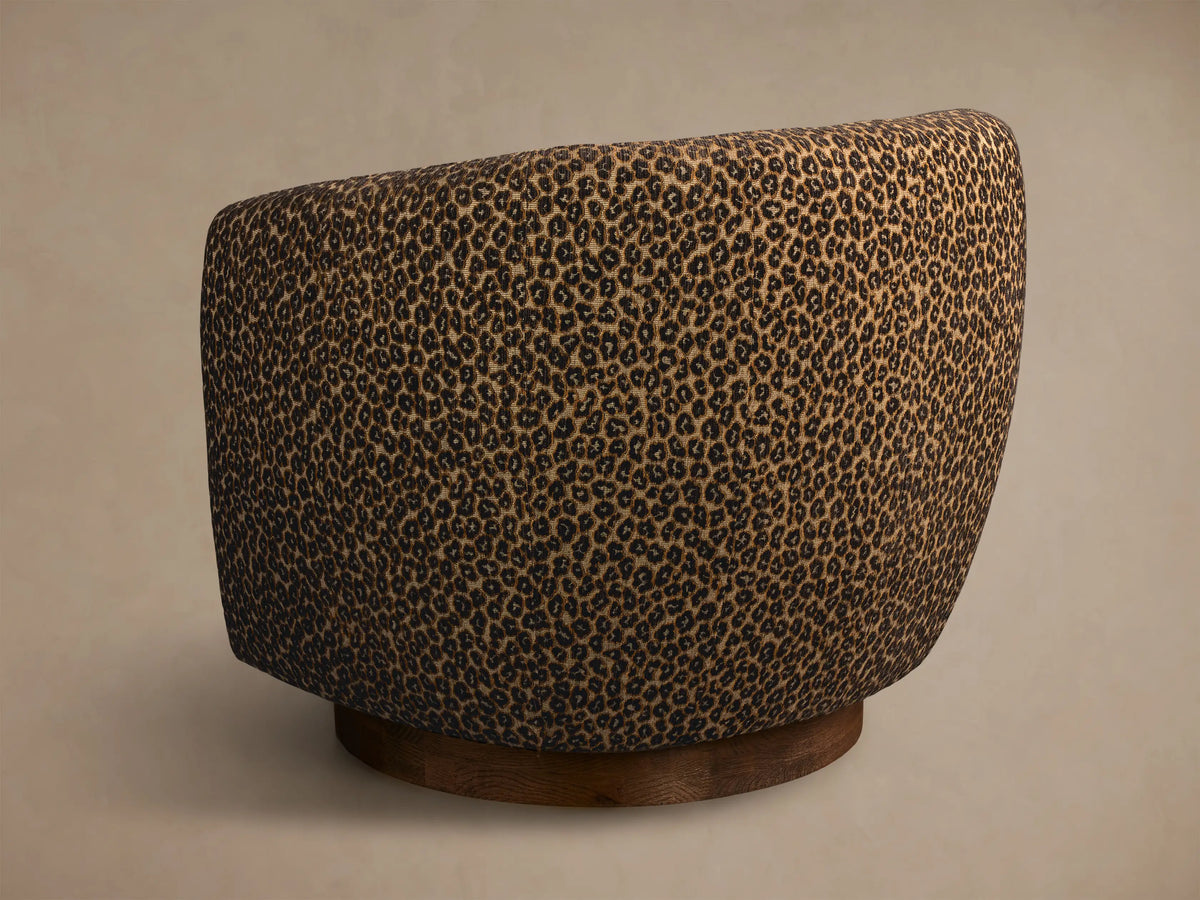 Rear view of the beige leopard print Cerrito Swivel Chair with a round wooden base.