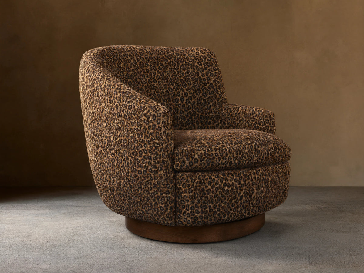Front-right view of the brown leopard print Cerrito Swivel Chair, featuring a rounded barrel shape and a dark wood swivel base.