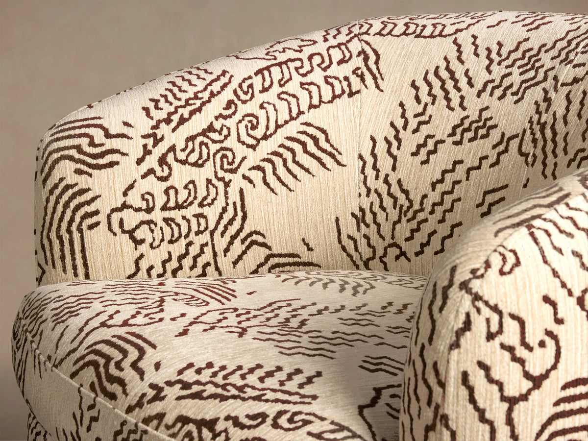 Front view of the Cerrito Swivel Chair in off-white fabric with a brown abstract pattern, featuring a rounded back and wooden swivel base.