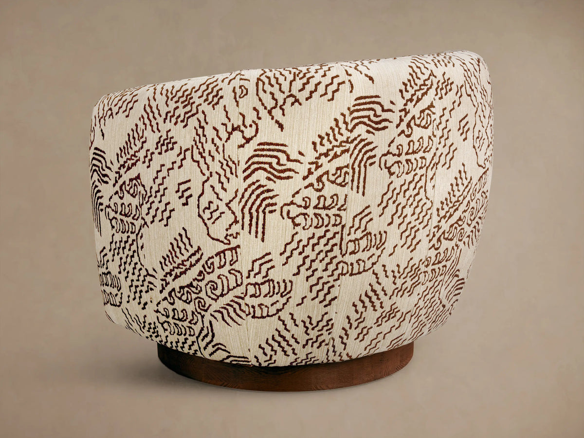 Close-up of the cream Cerrito Swivel Chair, featuring its dark brown abstract squiggly patterned upholstery.