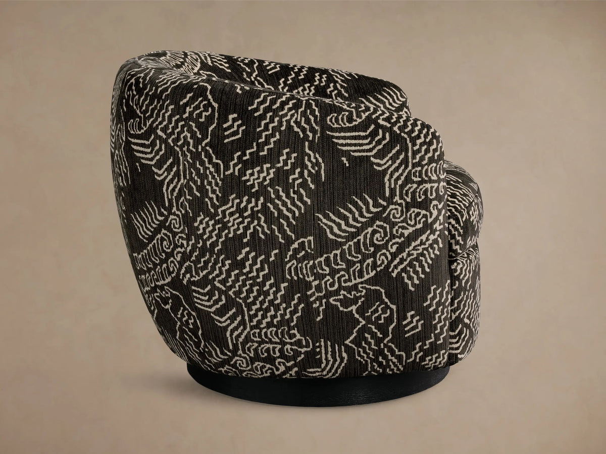 Side-back view of the black Cerrito Swivel Chair, featuring white abstract geometric patterned upholstery and a black swivel base.