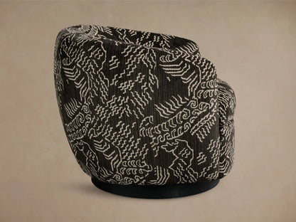 Side-back view of the black Cerrito Swivel Chair, featuring white abstract geometric patterned upholstery and a black swivel base.