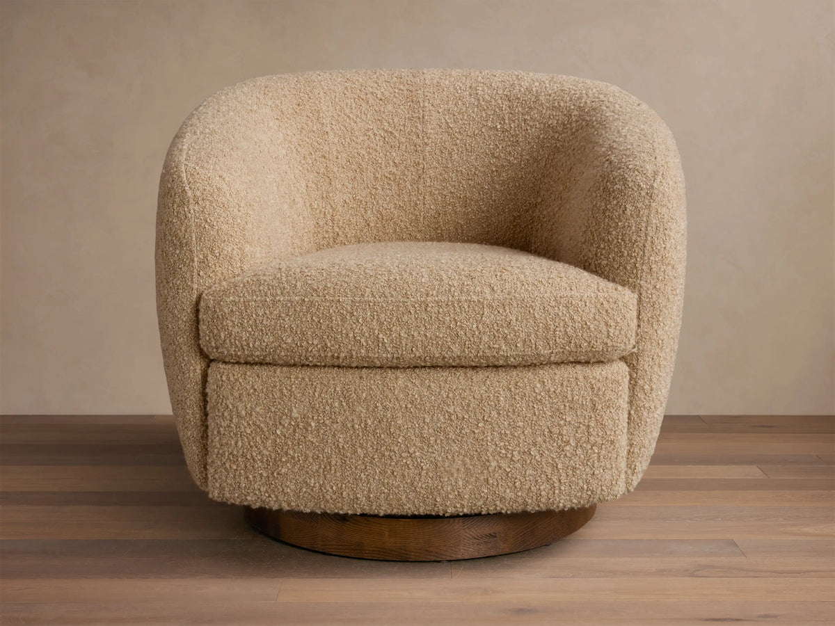 Front view of the light beige boucle Cerrito Swivel Chair with a rounded design and a dark wood swivel base.
