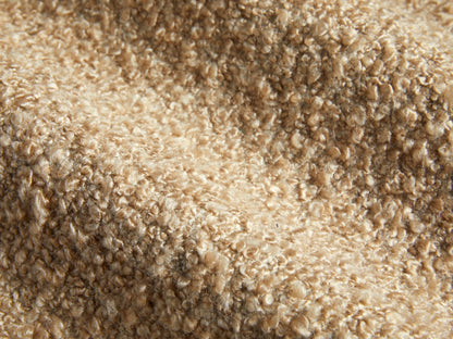 Side profile of a beige textured boucle Cerrito Swivel Chair with a dark wooden swivel base.
