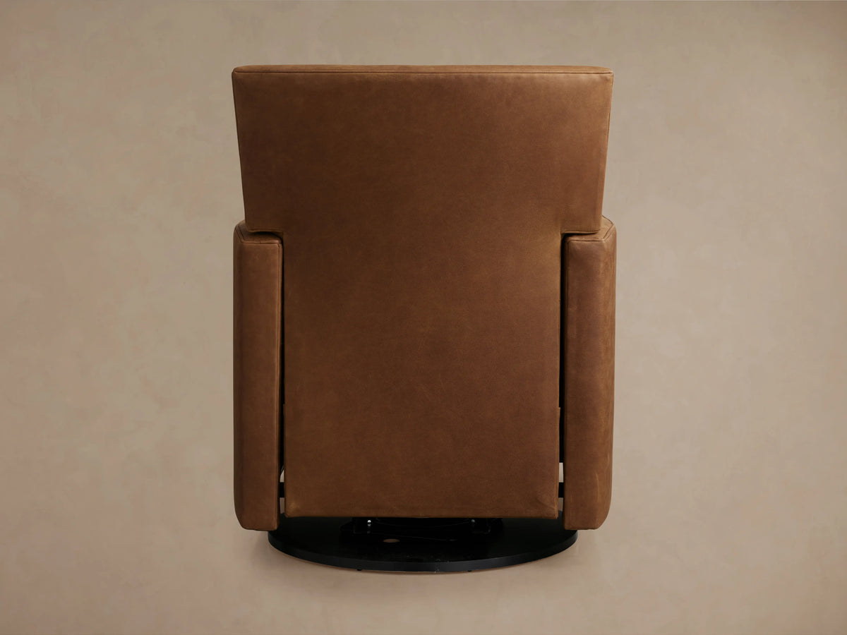 Rudy Leather Swivel Recliner in brown leather, viewed from the back, showing a tall rectangular backrest and straight arms on a circular black base.