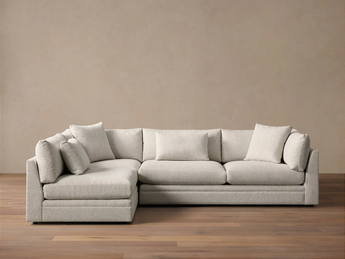 Front view of the light gray Pavo Two-Piece Sectional, an L-shaped sofa with plush seat and back cushions.
