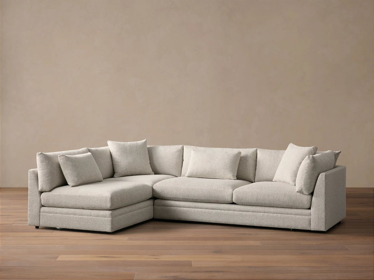 Front view of the light gray Pavo Two-Piece Sectional, an L-shaped sofa with plush seat and back cushions.