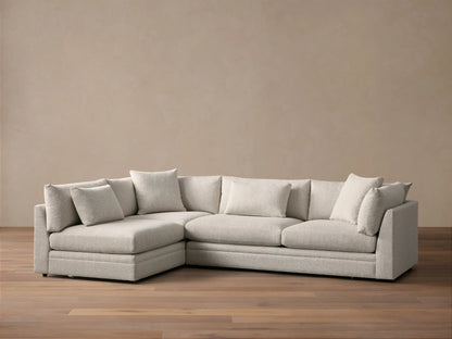 Front view of the light gray Pavo Two-Piece Sectional, an L-shaped sofa with plush seat and back cushions.