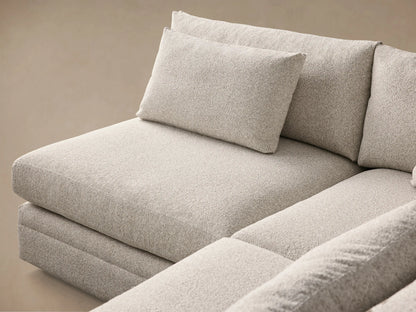 Front view of a light beige Pavo Two-Piece Sectional with a left-facing chaise, featuring deep seats and plump cushions.