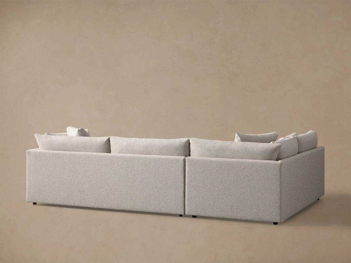 Angled close-up view of the light beige Pavo Two-Piece Sectional, showing plush, textured fabric cushions.