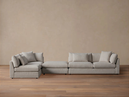 Rear-side view of the light grey Pavo Three-Piece Sectional, showcasing its modular design and textured fabric with back cushions.