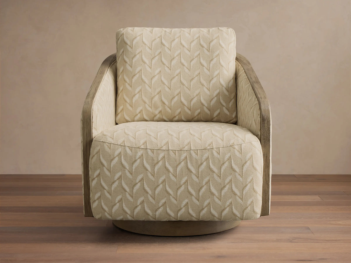 Front-right view of the beige Pomona Swivel Chair, featuring exposed oak arms and an oak swivel base.