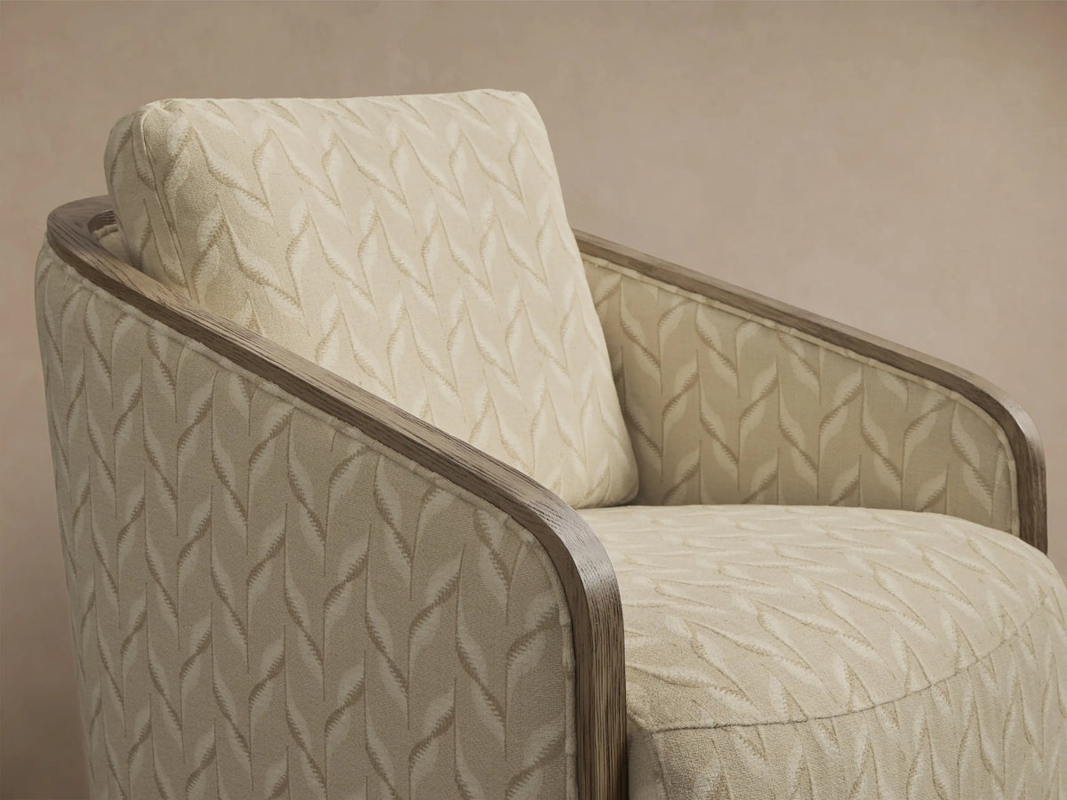 Front view of the cream geometric leaf pattern Pomona Swivel Chair with exposed oak arms and swivel base.