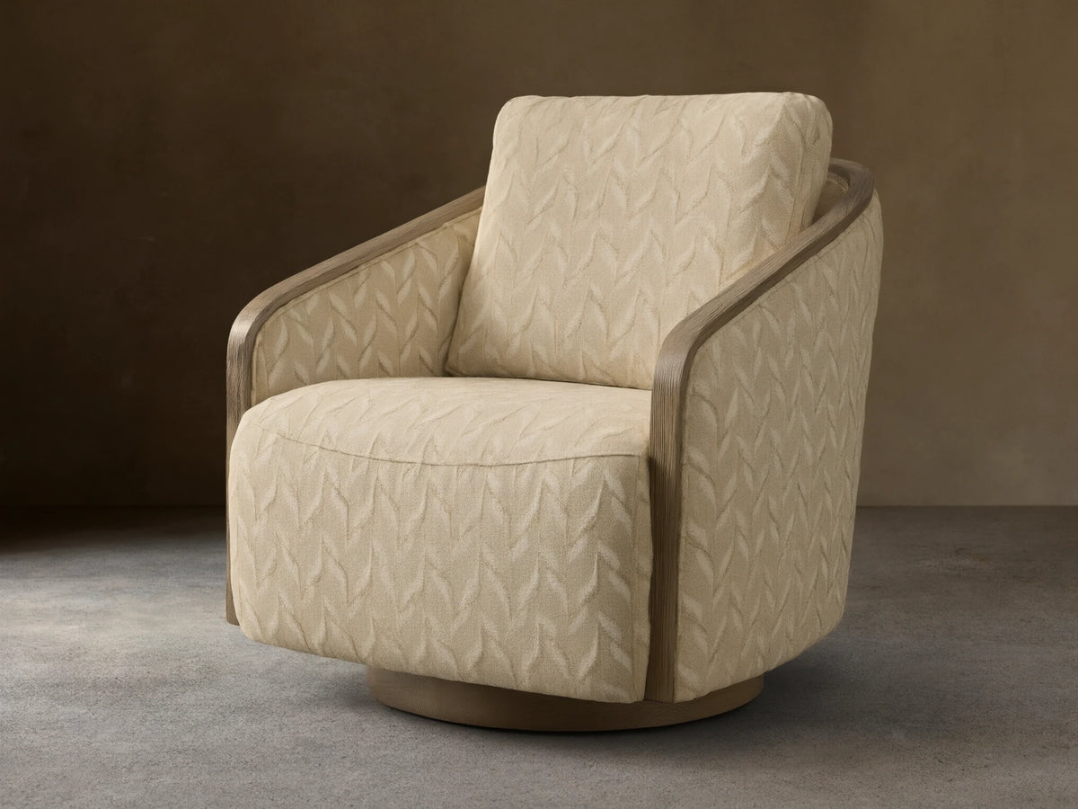 Front view of the beige leaf-patterned Pomona Swivel Chair, with exposed light oak arms and a round swivel base.
