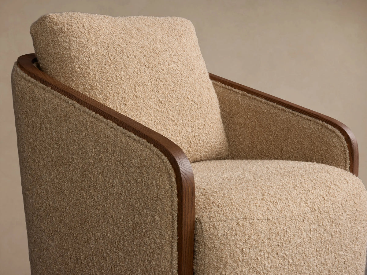 Front view of the beige bouclv© Pomona Swivel Chair with exposed oak arm edges and a wooden swivel base.