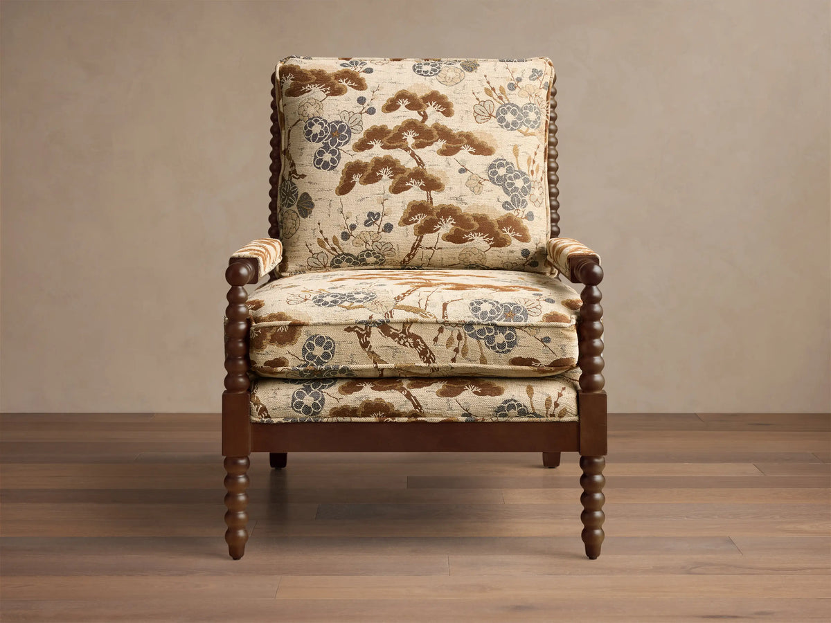 Front view of the beige, brown, and blue patterned upholstery Milly Chair with dark brown spindled wood arms and legs.
