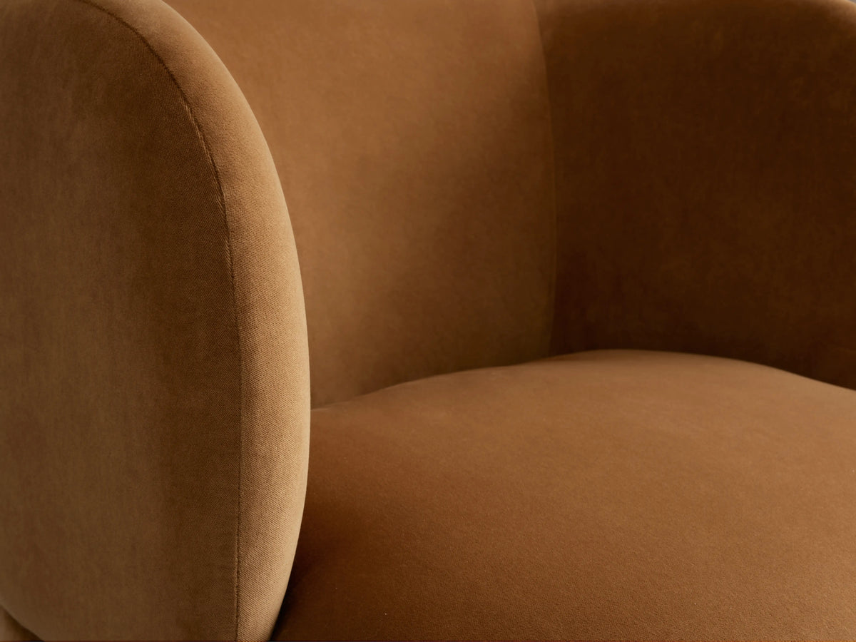 Lenny Swivel Chair in light brown upholstery, featuring curved backrest and rounded seat, positioned on wooden floor.