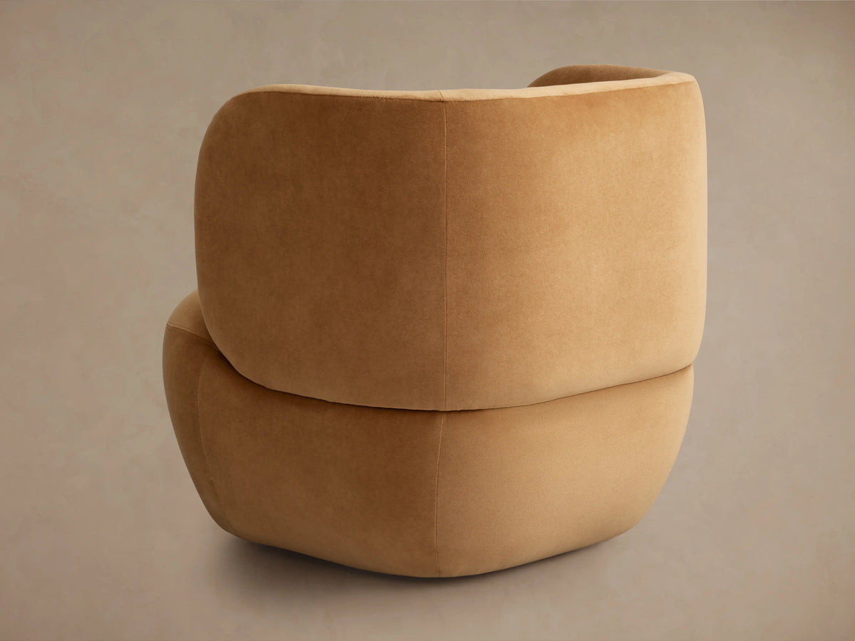 Brown Lenny Swivel Chair close-up, showing soft, rounded armrest and seat cushion with smooth fabric texture.