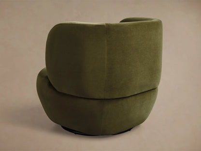 Close-up of green velvet armchair, highlighting the curved backrest and armrest with soft, plush fabric.