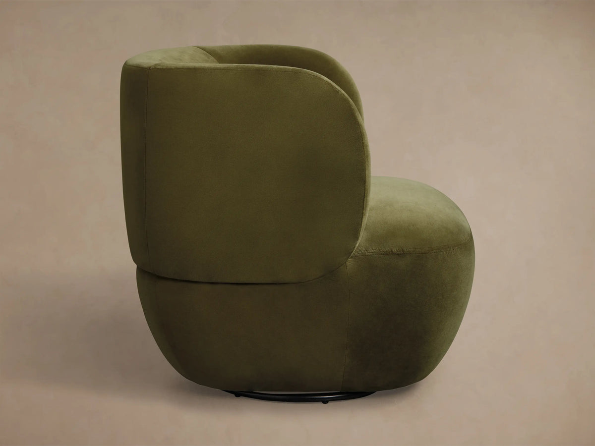 Rear view of an olive green upholstered swivel accent chair with a curved back and a black base.