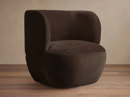 Dark brown Lenny Swivel Chair with plush, rounded backrest and seat, set on a wooden floor. The chair features a seamless, modern design.