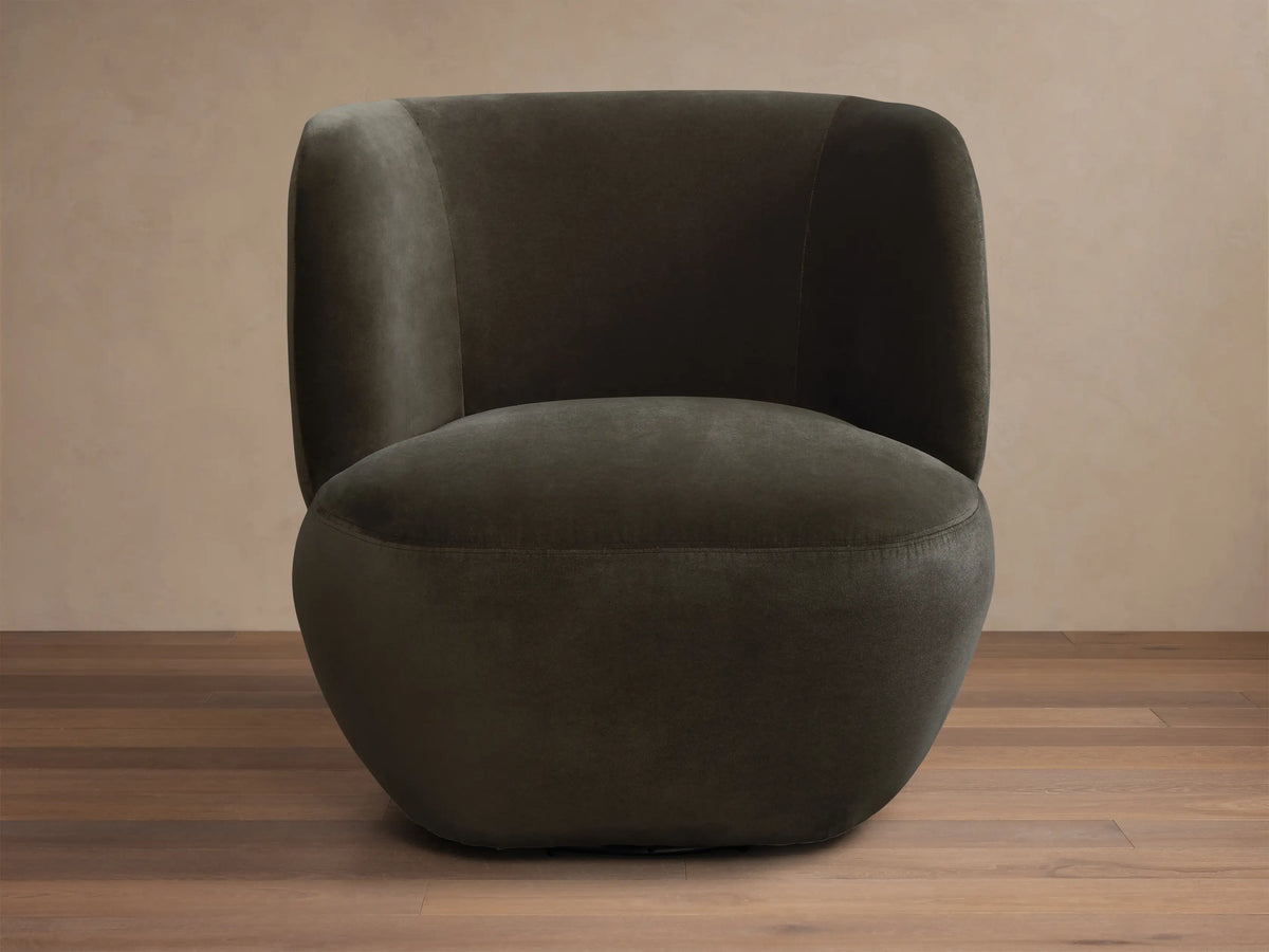 Front-side view of a dark olive green upholstered barrel chair with seamless, rounded arms and back.