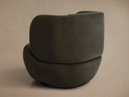 Close-up of dark olive green upholstered chair with curved back and deep, plush seat in soft fabric.