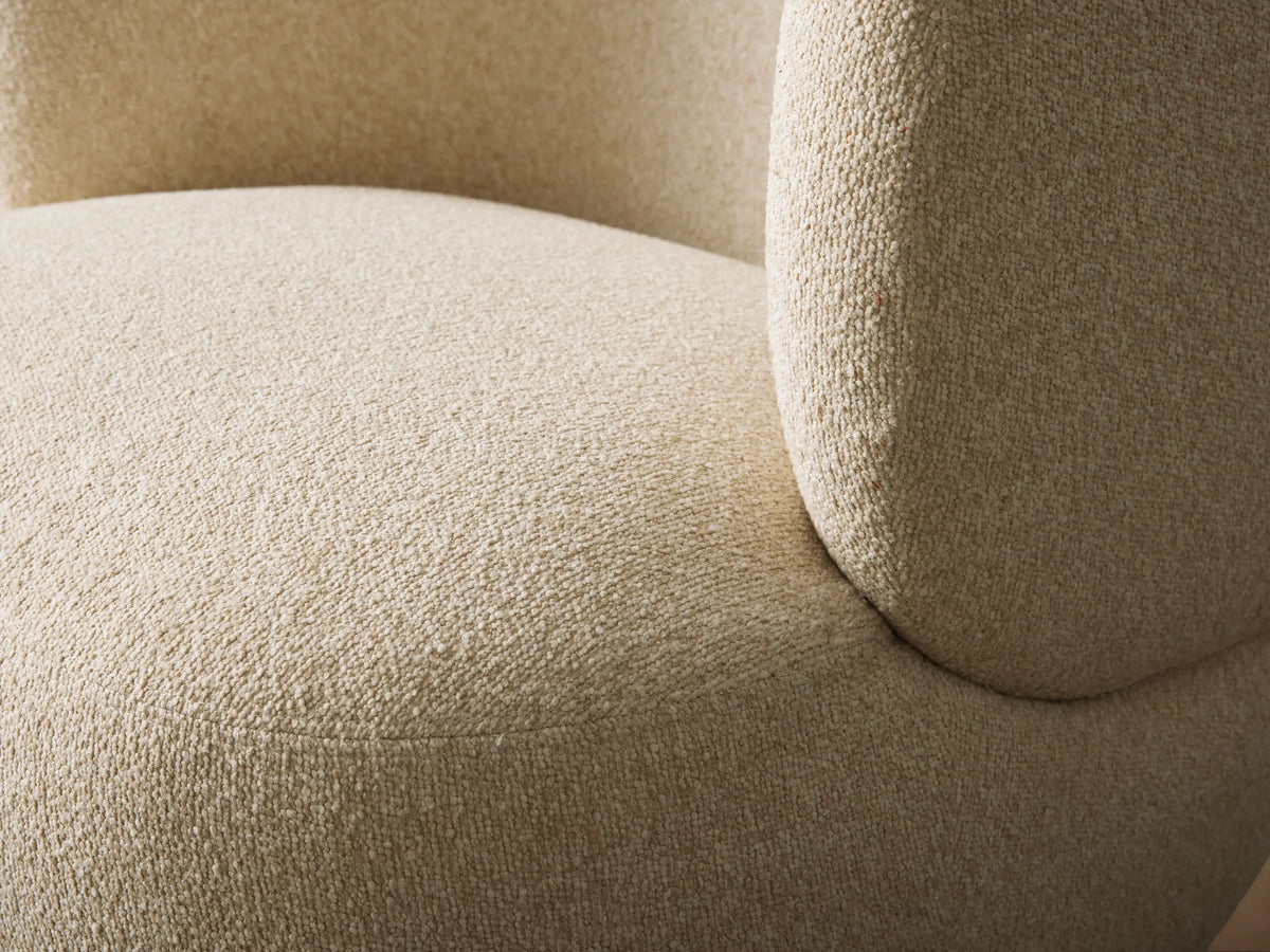 Lenny Swivel Chair. Off-white textured fabric chair with a low, curved back and rounded seat, centered on a wooden floor.