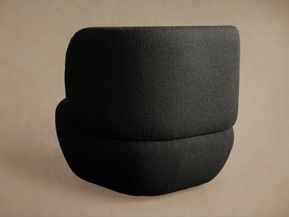 Close-up of Lenny Swivel Chair's dark grey, boucl??-like textured fabric upholstery, highlighting a gentle curve.