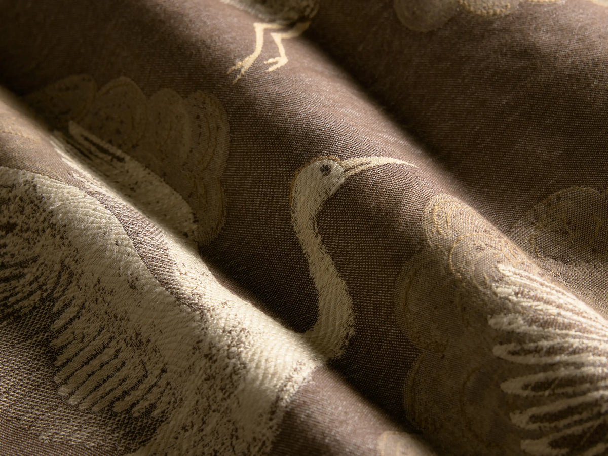 Rear view of the Tilly Chair, featuring a brown wooden frame, beige back upholstery, and a multi-colored patterned seat with brass nailheads.
