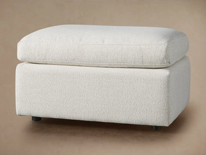 Ashby Ottoman in light beige CryptonÂ® fabric with a rectangular shape, cushioned top, and subtle texture on a neutral background.
