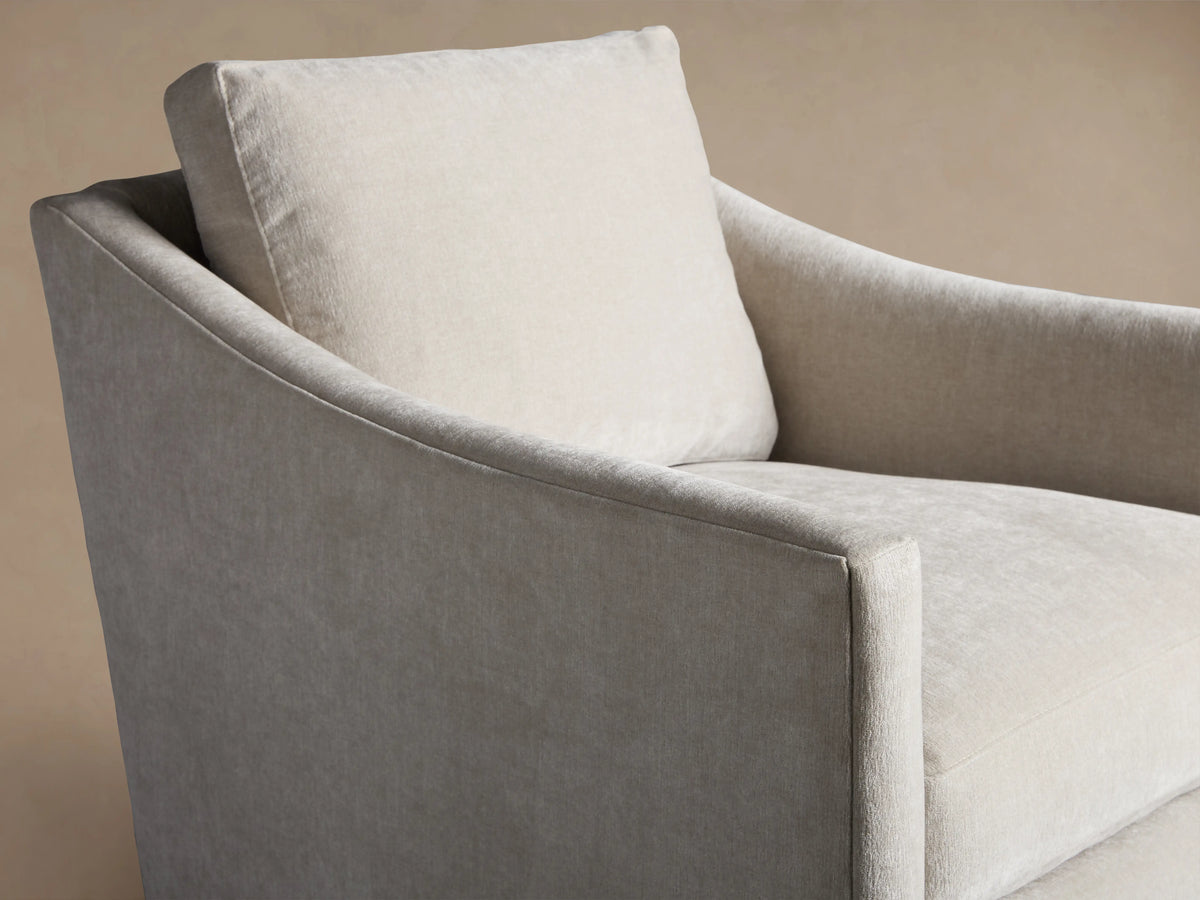 Branson Swivel Chair in light grey fabric, featuring plush seat and back cushions, soft armrests, on a wooden floor.