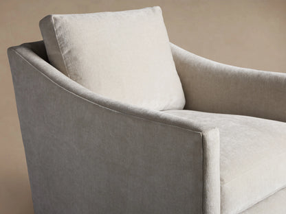 Branson Swivel Chair in light grey fabric, featuring plush seat and back cushions, soft armrests, on a wooden floor.