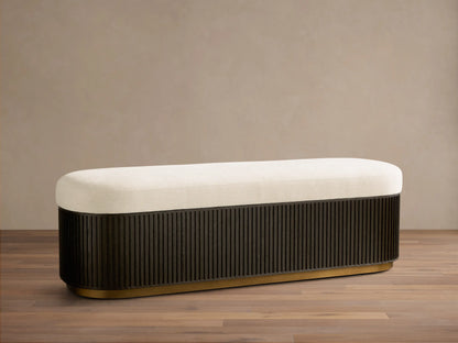 Front view of the cream-cushioned Finnley Storage Bench with a fluted black base and gold trim.