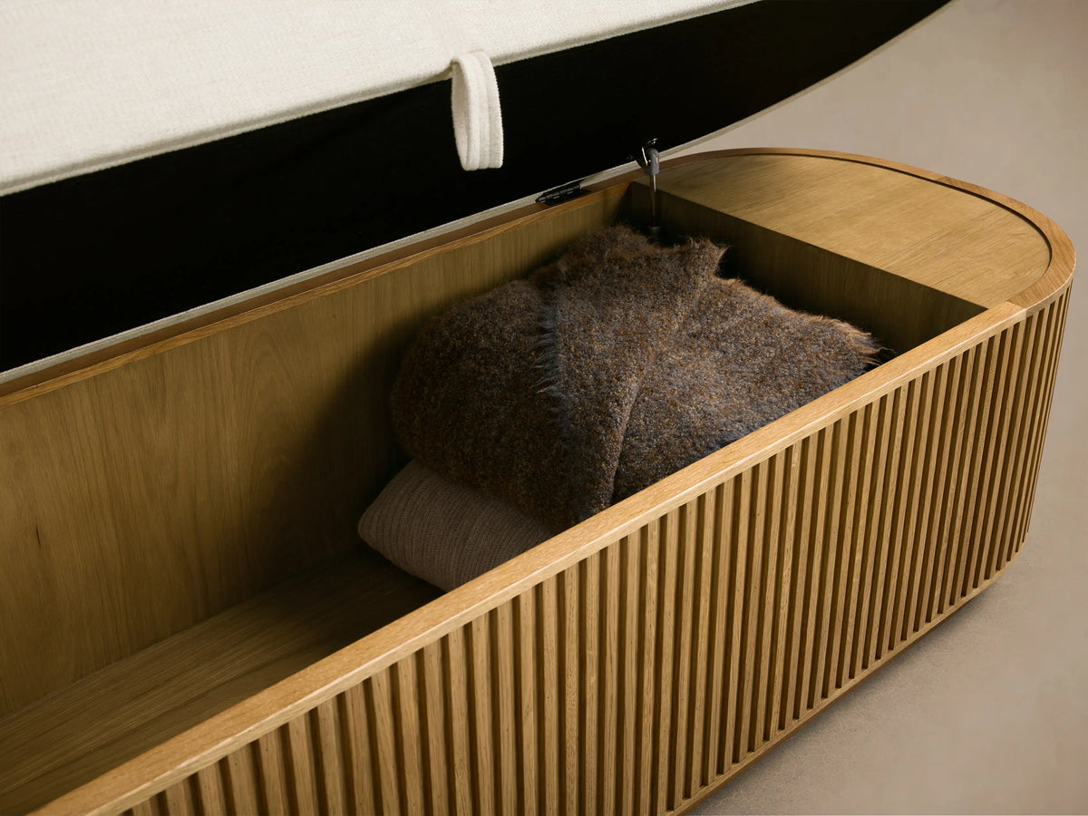 Front view of the Finnley Storage Bench, featuring a cream upholstered top and a slatted honey oak wood base.