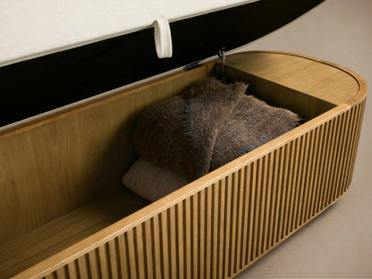 Front view of the Finnley Storage Bench, featuring a cream upholstered top and a slatted honey oak wood base.