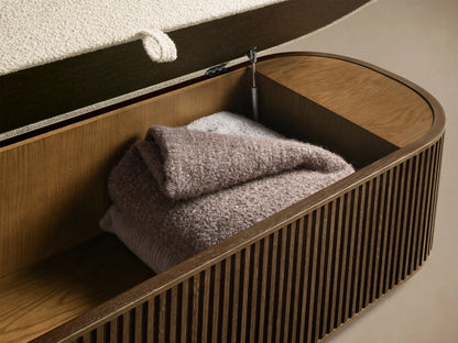 Interior view of the open Mocha Finnley Storage Bench in slatted red oak, holding folded taupe blankets, with a cream cushion lid.