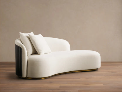 Front view of a cream Finnley Daybed with a curved shape, dark ribbed wood panel, two matching pillows, and a brass base.