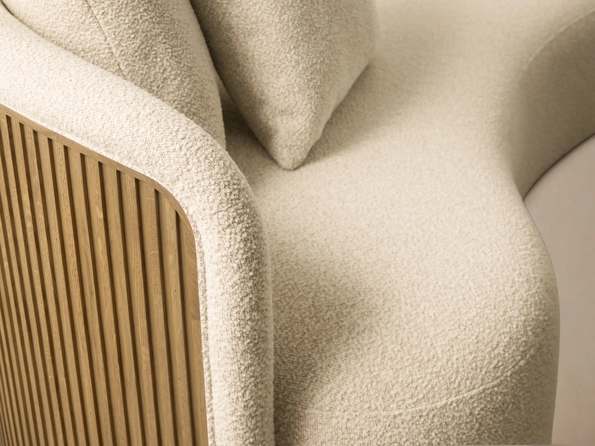 Front view of the cream Finnley Daybed, featuring a curved backrest, two matching toss pillows, and a long seat on a golden base.