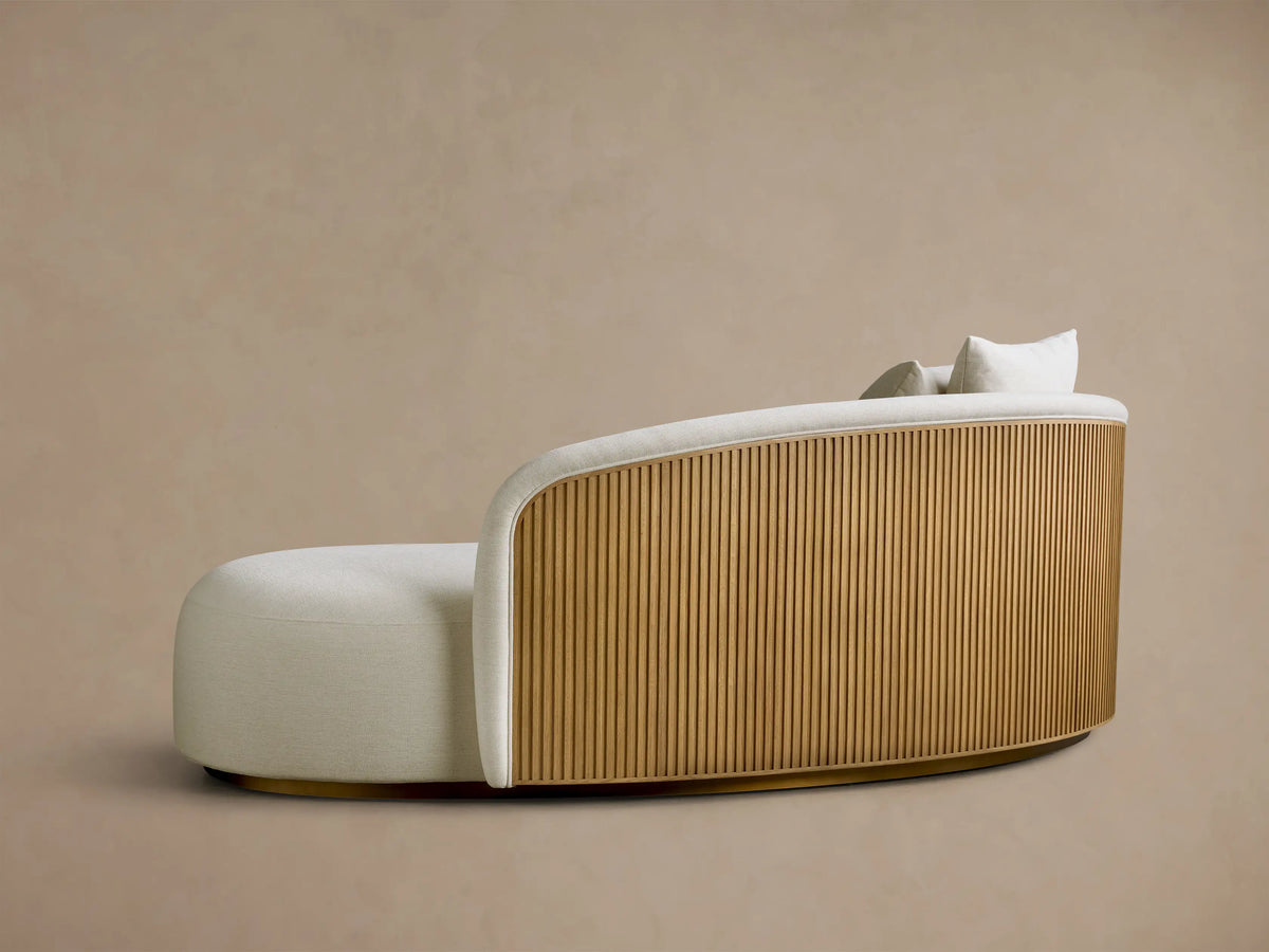 Rear view of the Finnley Daybed, featuring honey vertical wood slats and light fabric upholstery with two toss pillows.