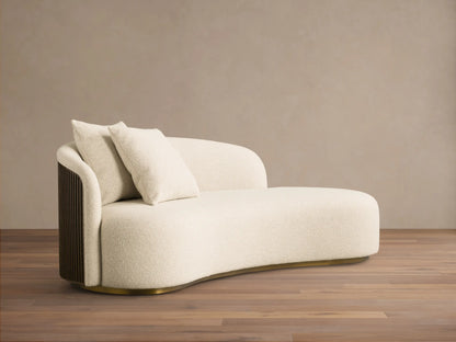 Cream Finnley Daybed with a curved design, textured upholstery, dark slatted wood panel, gold base, and two toss pillows.