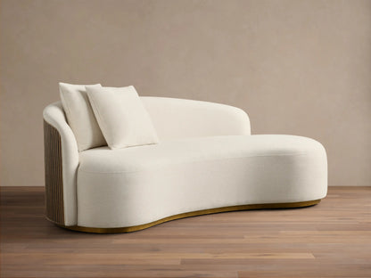 Front view of the Off-white Finnley Daybed, an asymmetrical daybed with two matching pillows and a curved gold-toned base.