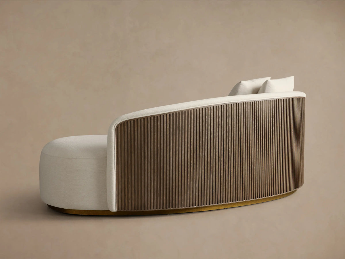 Close-up of the cream Finnley Daybed, showing its textured upholstery, two pillows, and curved slatted wooden side.