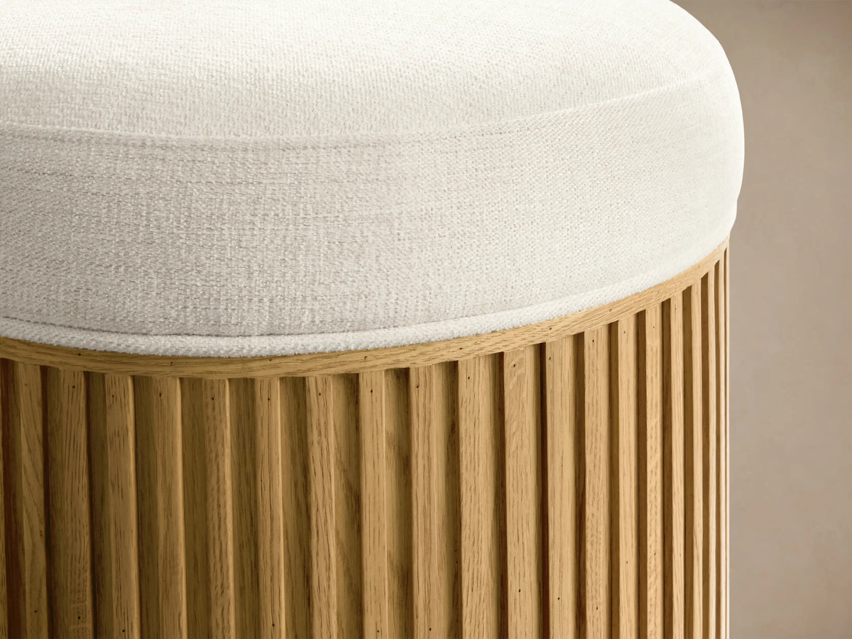 Top-down view of a round Cream Finnley Ottoman with a textured fabric.