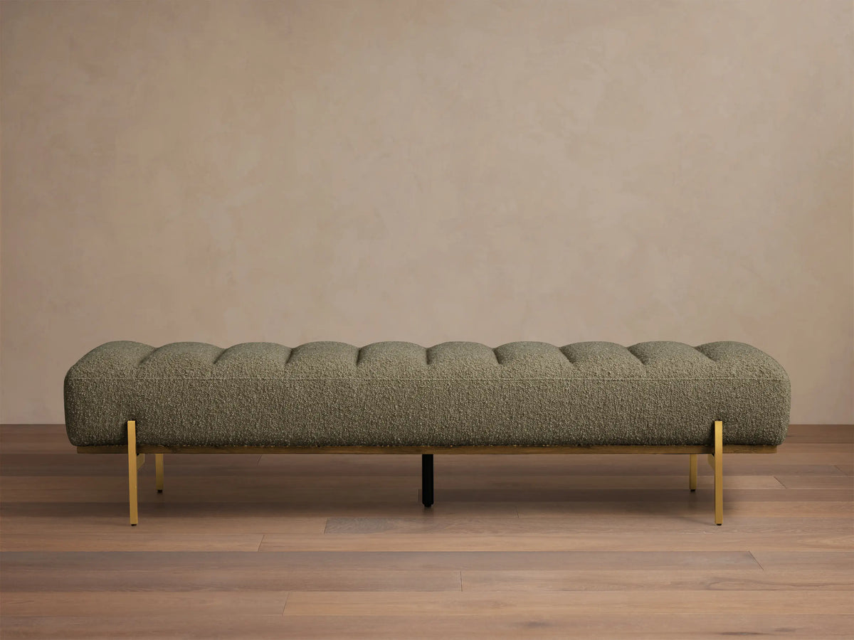 Front view of the olive green Lansing Bench, featuring channel-tufted upholstery and slender gold-colored metal legs.