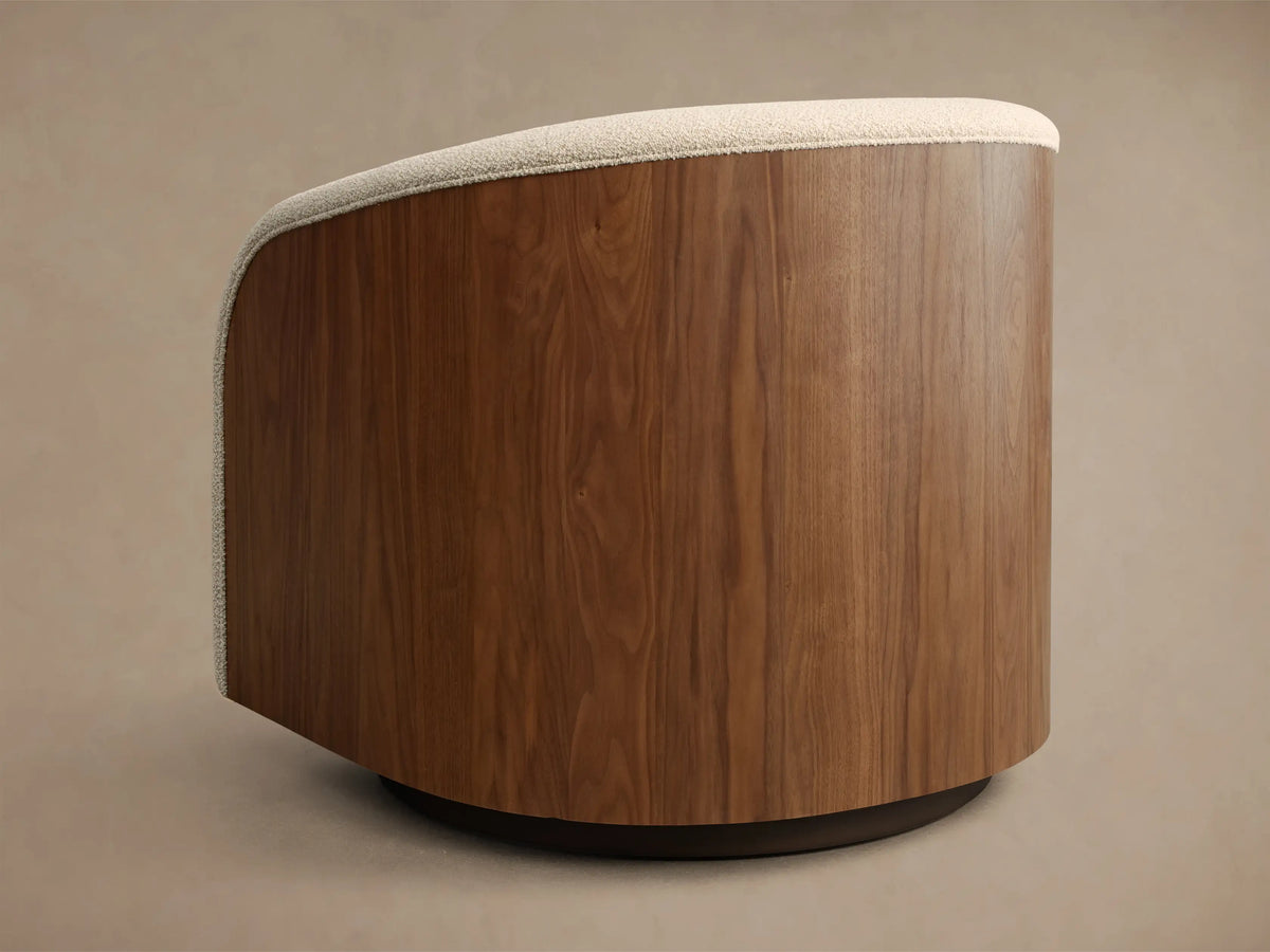 Close-up of a curved chair featuring cream boucle upholstery and a dark wooden side panel with visible wood grain.
