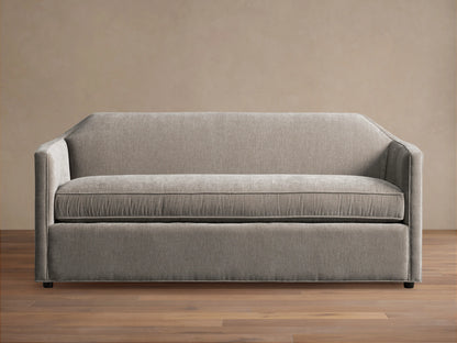Grey Marina Sofa with a sleek, modern design featuring straight arms and a plush seat cushion. Sits on a hardwood floor with a neutral background.