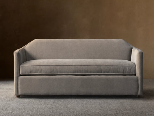 Grey Marina Sofa with a sleek, modern design featuring straight arms and a plush seat cushion. Sits on a hardwood floor with a neutral background.