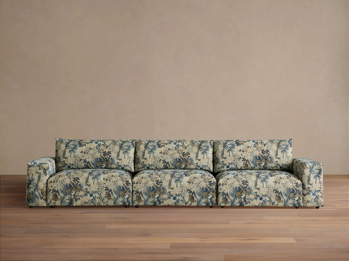 Keegan Three Piece Modular Sofa, upholstered in blue, beige, and brown floral fabric, front view, on a wooden floor.